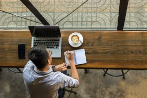 a man writing on a notebook